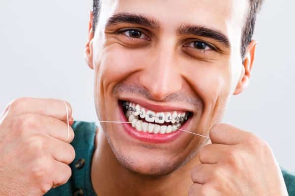 guy-flossing-with-braces