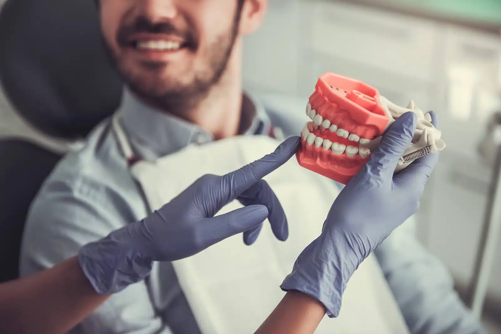 Orthodontist explaining jaw alignment using a dental model to demonstrate virtual jaw surgery planning