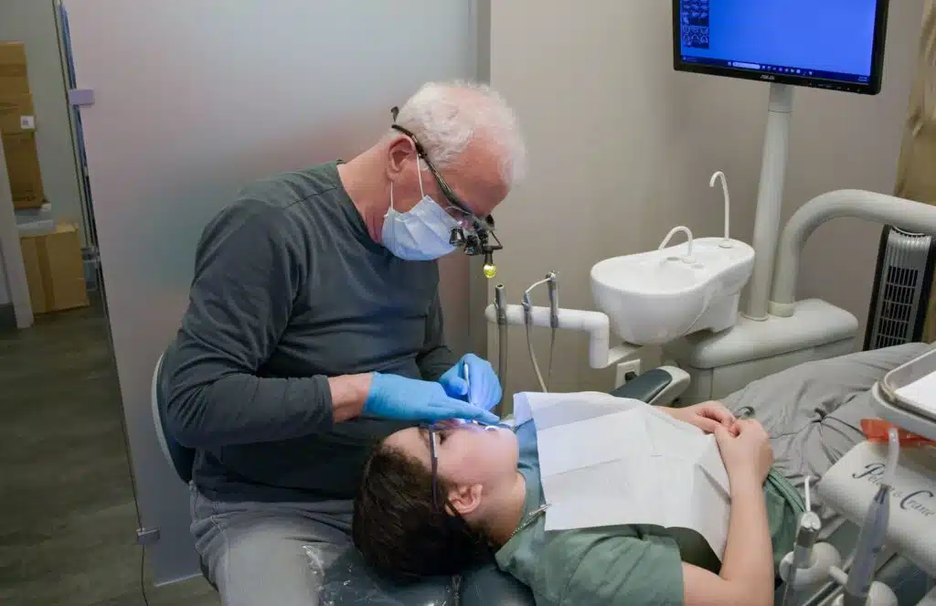 Dr. Bob Bryan using specialized dental loupes to examine a young patient's braces
