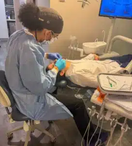 An orthodontic assistant performing a clinical procedure on a patient at Hanson Place Orthodontics