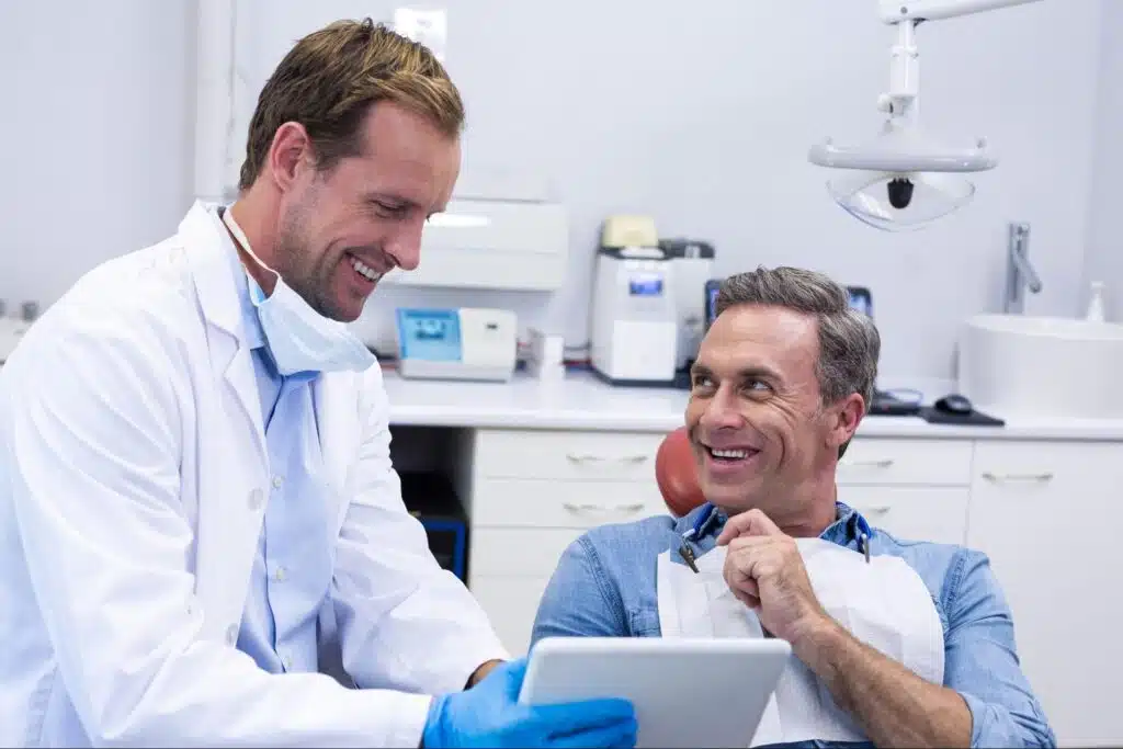 Dentist showing digital treatment plan on a tablet to a patient
